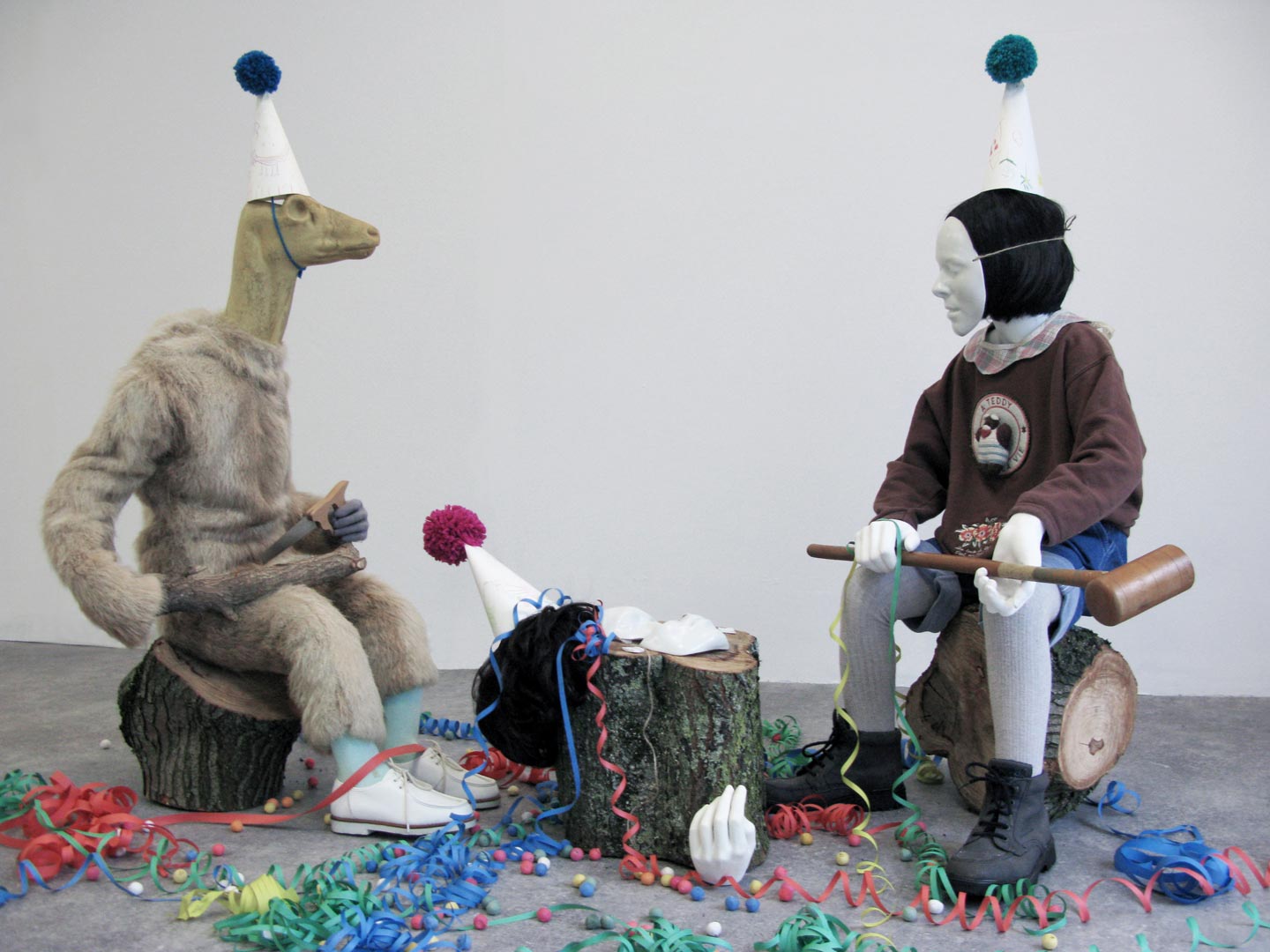 Vues de l'installation intitulée "Joyeuses Pétoches". L'installation présente des figures enfantines, hybrides ou costumées dans les vestiges d’une célébration.